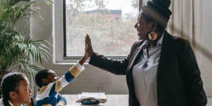 A teacher high-fiving her student, presumably after mastering one of the most challenging Common Core standards.