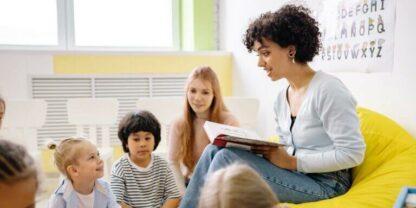 A teacher reading to a group of students on National Read-a-Book Day.