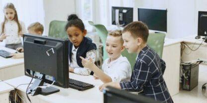 Three students working together at a PC workstation.