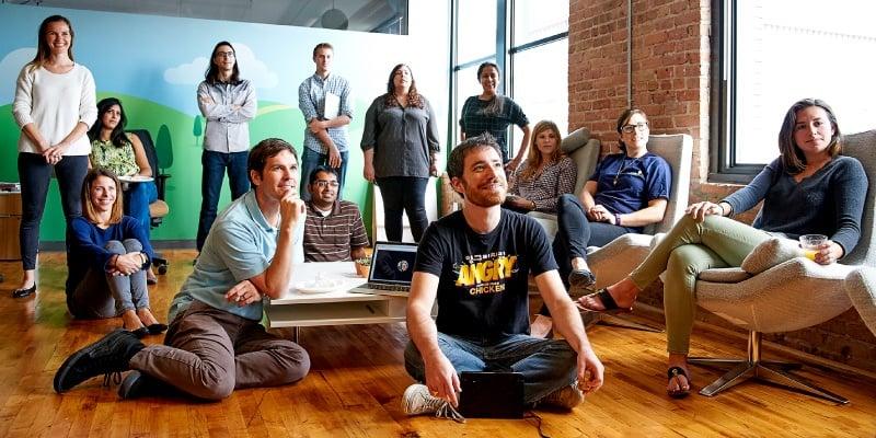 eSpark team members both seated and standing watching a presentation.