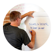 An eSpark employee writing on a whiteboard.