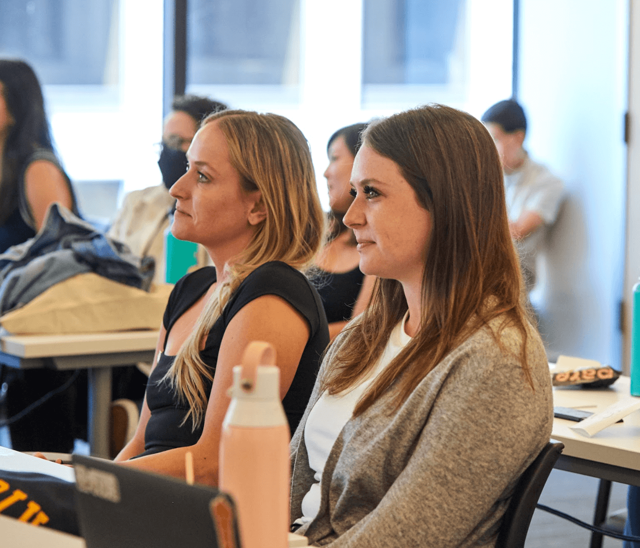 Two eSpark team members in the foreground watching a presentation.