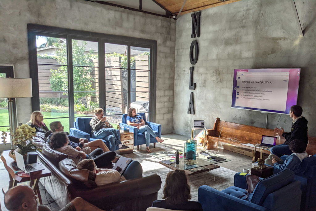 An image of the eSpark team in a casual workspace watching a monitor.