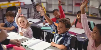 students in classroom raising their hand