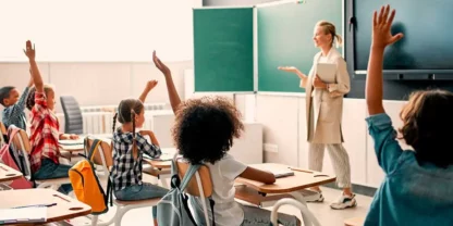 Teacher looking at classroom with students raising their hands