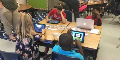 Classroom with students working on tablets and computers