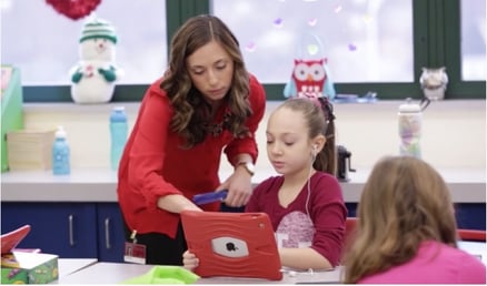 Teacher helping student with iPad